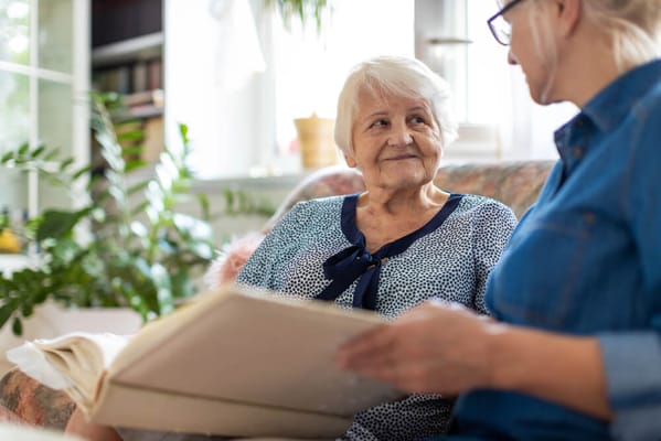 A senior resident engaged in conversation with a caregiver