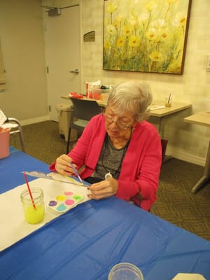 Resident painting at an activity table