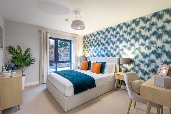 Well-furnished bedroom with blue accents and natural light