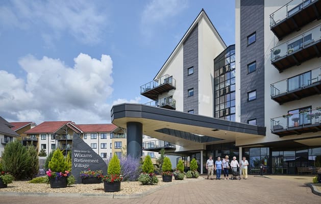 Exterior view of Wixams Retirement Village with staff outside
