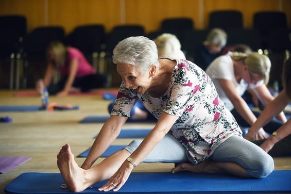 Residents participating in a yoga class in an activity room