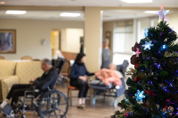 Residents enjoying a festive common area decorated for Christmas