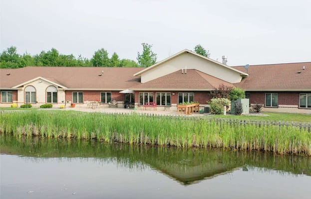 Exterior view of Willow Brooke with landscaped area and pond