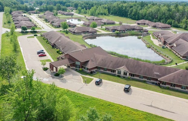 Aerial view of a senior living complex with greenery and water