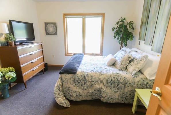 Cozy bedroom with a floral comforter and natural light