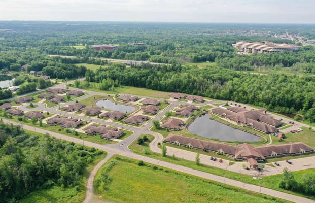 Aerial view of a senior living campus with greenery and ponds