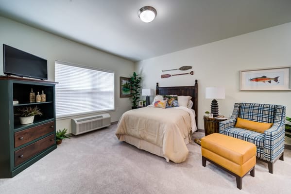 Well-decorated bedroom with a bed, TV, and seating area