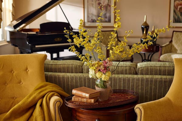 Cozy common area with decorative flowers and piano