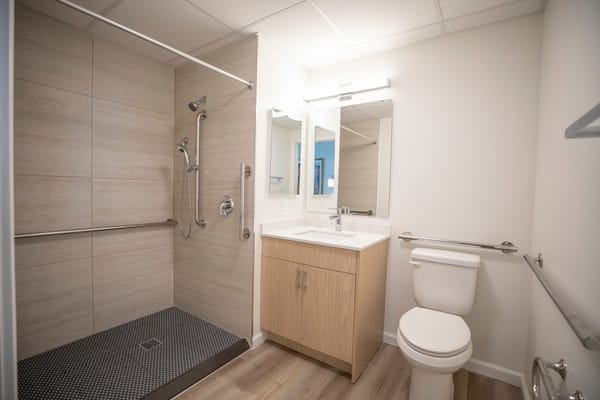 A clean, modern bathroom with grab bars
