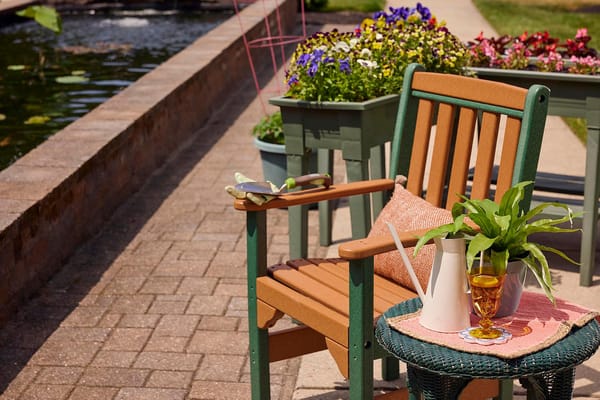 Outdoor seating area with plants and a drink