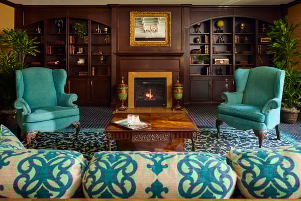 Cozy lounge area with teal chairs and a fireplace