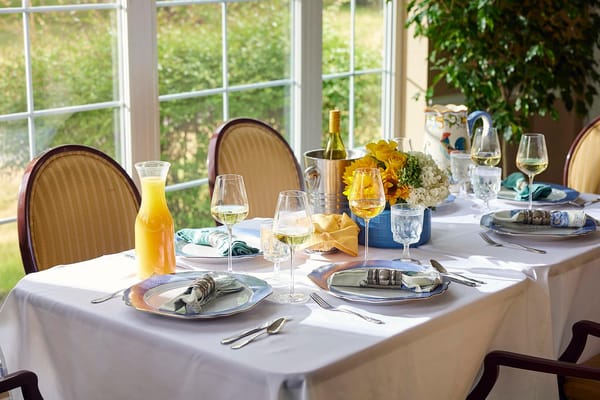 Well-set dining table with drinks and flowers