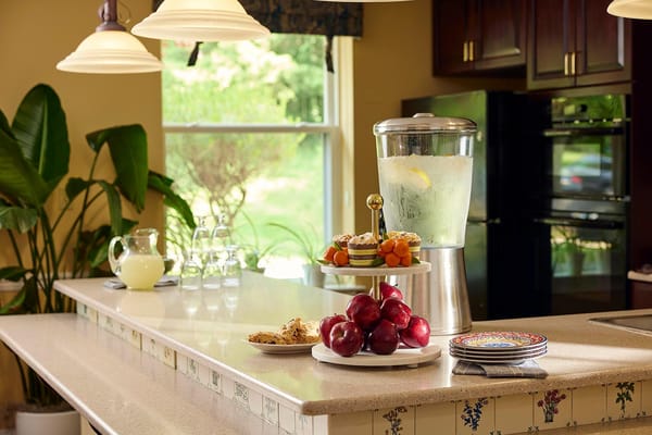 Well-lit kitchen area with refreshments and fruits
