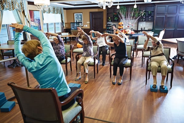 Residents participating in a seated exercise class