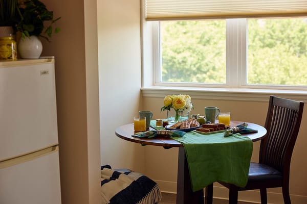 A cozy dining setup with breakfast items and flowers on the table