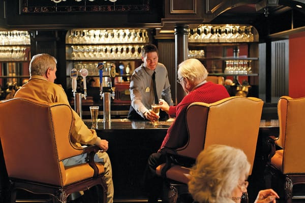 Residents enjoying drinks at the bar with staff member serving them