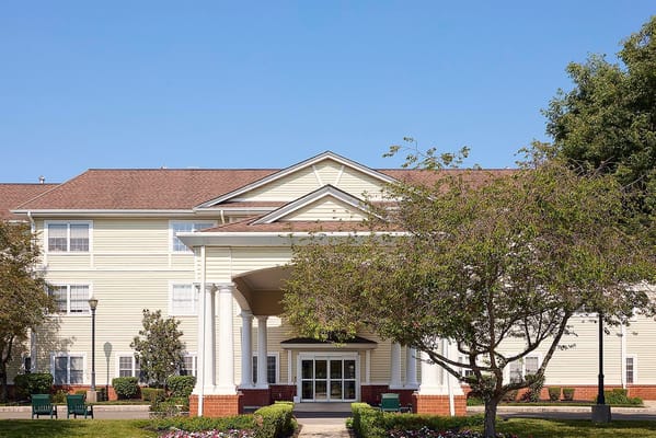 Exterior view of an assisted living facility with lush landscaping