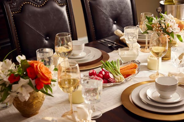 Elegantly set dining table with flowers and dishes