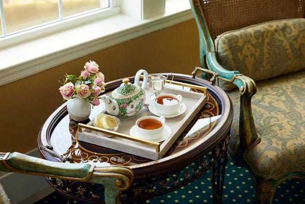 Tea and roses on a decorative table in a cozy interior