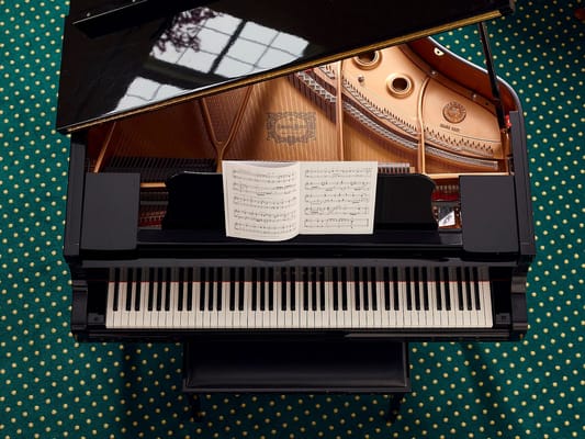 A grand piano with sheet music on top