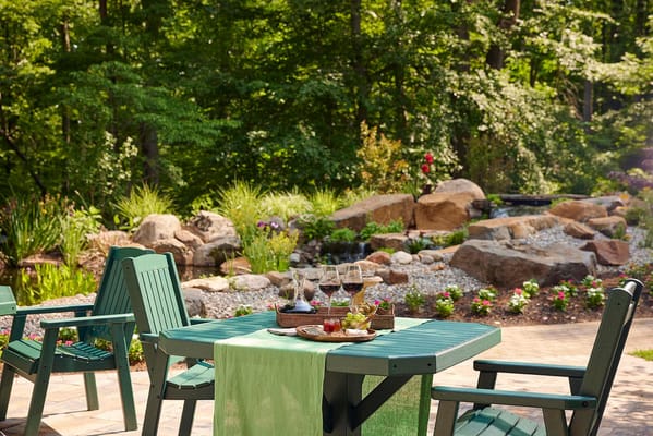 Outdoor seating area with wine glasses and a peaceful garden