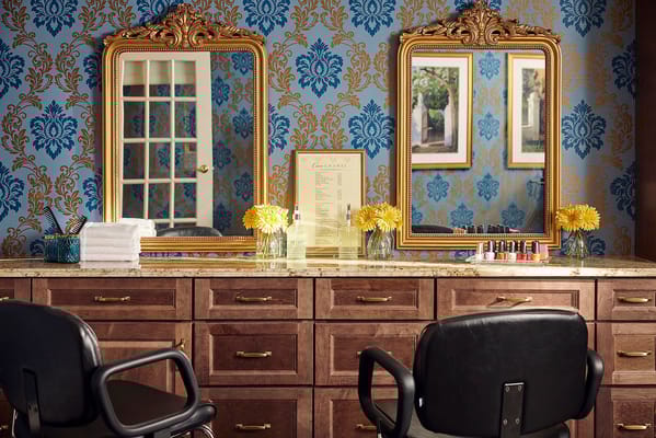 Interior view of a salon area with mirrors and flowers