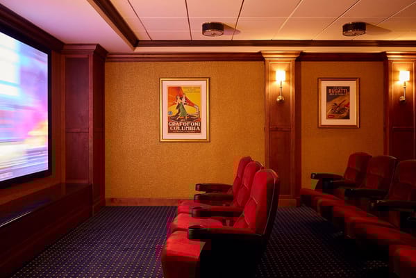 Private theater room with red seating and classic movie posters