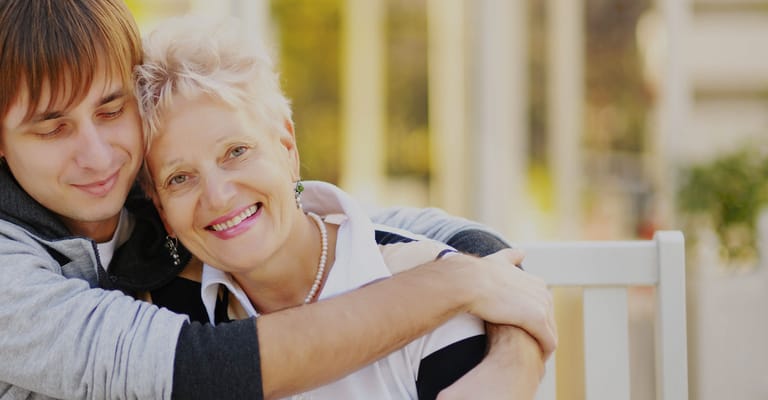 A resident embracing a visitor, sharing joy