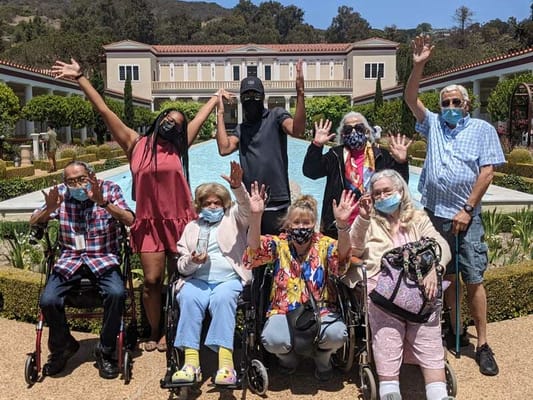 Residents and staff celebrating outdoors with raised hands