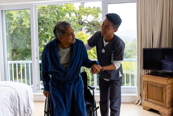 A caregiver assisting a resident in a bright room