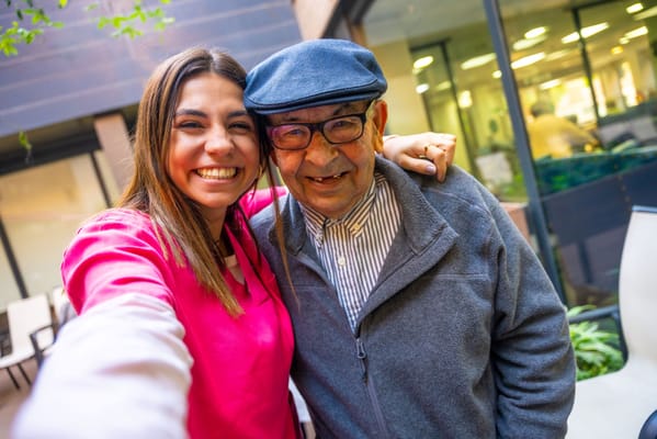 Staff member and resident smiling together outdoors