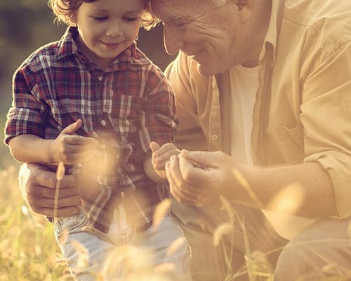 A senior man enjoying time outdoors with a child