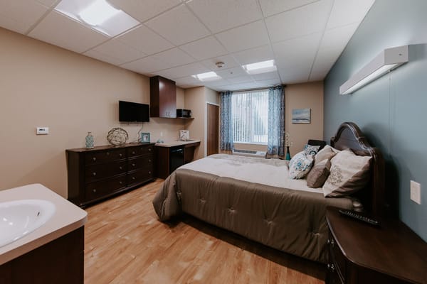 A well-furnished resident room with natural light