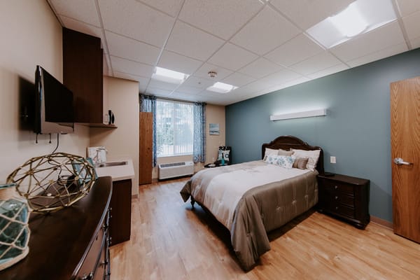 Comfortable resident room with a cozy bed and decor