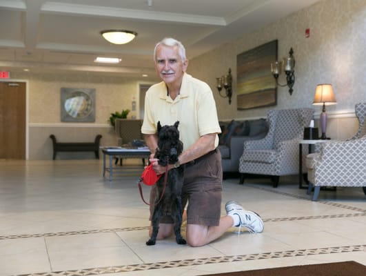 Senior resident with a dog in a common area
