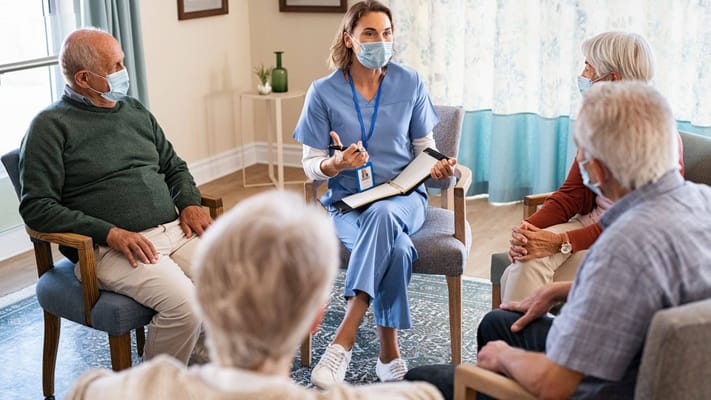 A caregiver leading a discussion group with residents