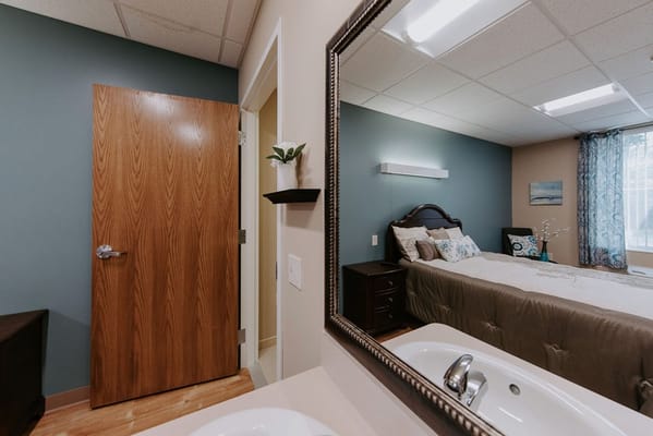 Interior view of a resident room with a bed and mirror