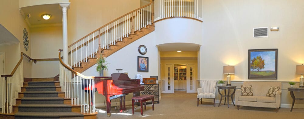Bright interior of a common area with a piano and seating