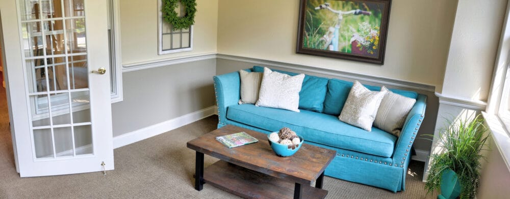 Bright common area with turquoise couch and decorative elements