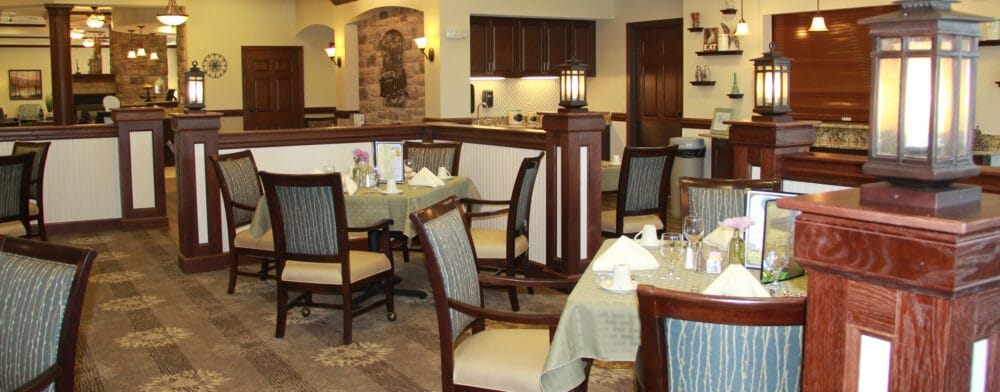 Dining area with tables and chairs in a senior living facility