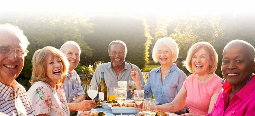 Residents enjoying a meal and laughter outdoors