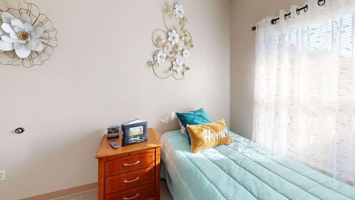 A private resident room with a bed and decor