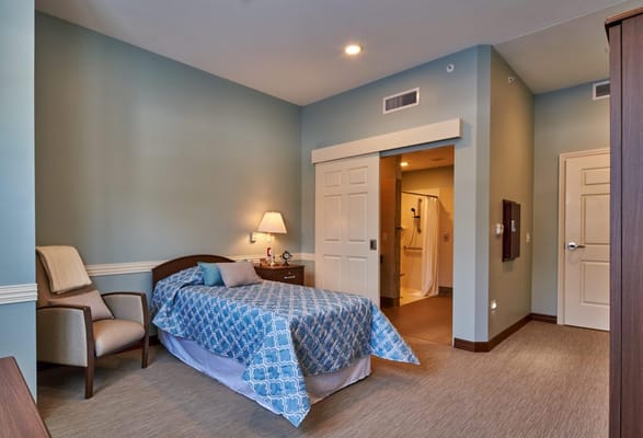 Well-furnished private resident room with a bed and seating