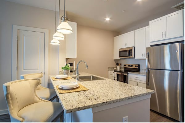Bright kitchen area with granite countertops and modern appliances