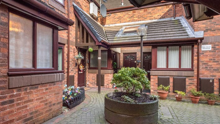 A landscaped courtyard with brick walls and potted plants at Smethurst Court.