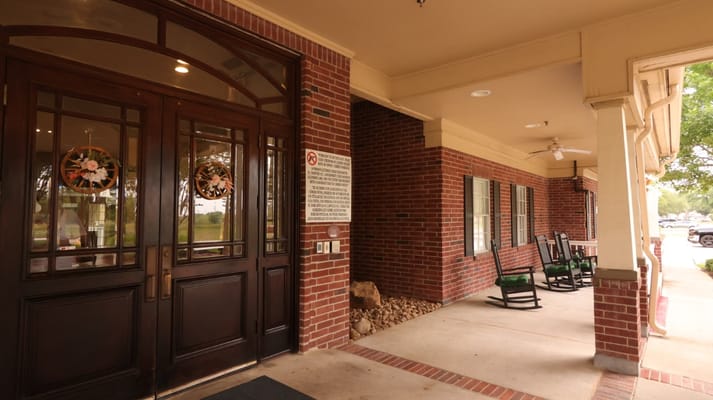 Front entrance with double doors and rocking chairs