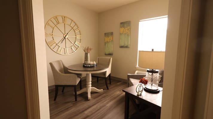 A cozy seating area with a table, lamp, and floral decorations