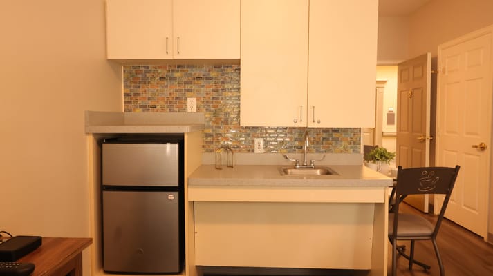 Modern kitchenette with sink and refrigerator