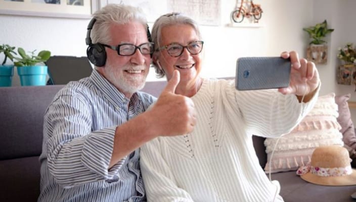 Two seniors smiling and taking a selfie