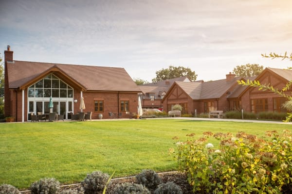 Exterior view of a nursing home facility with gardens
